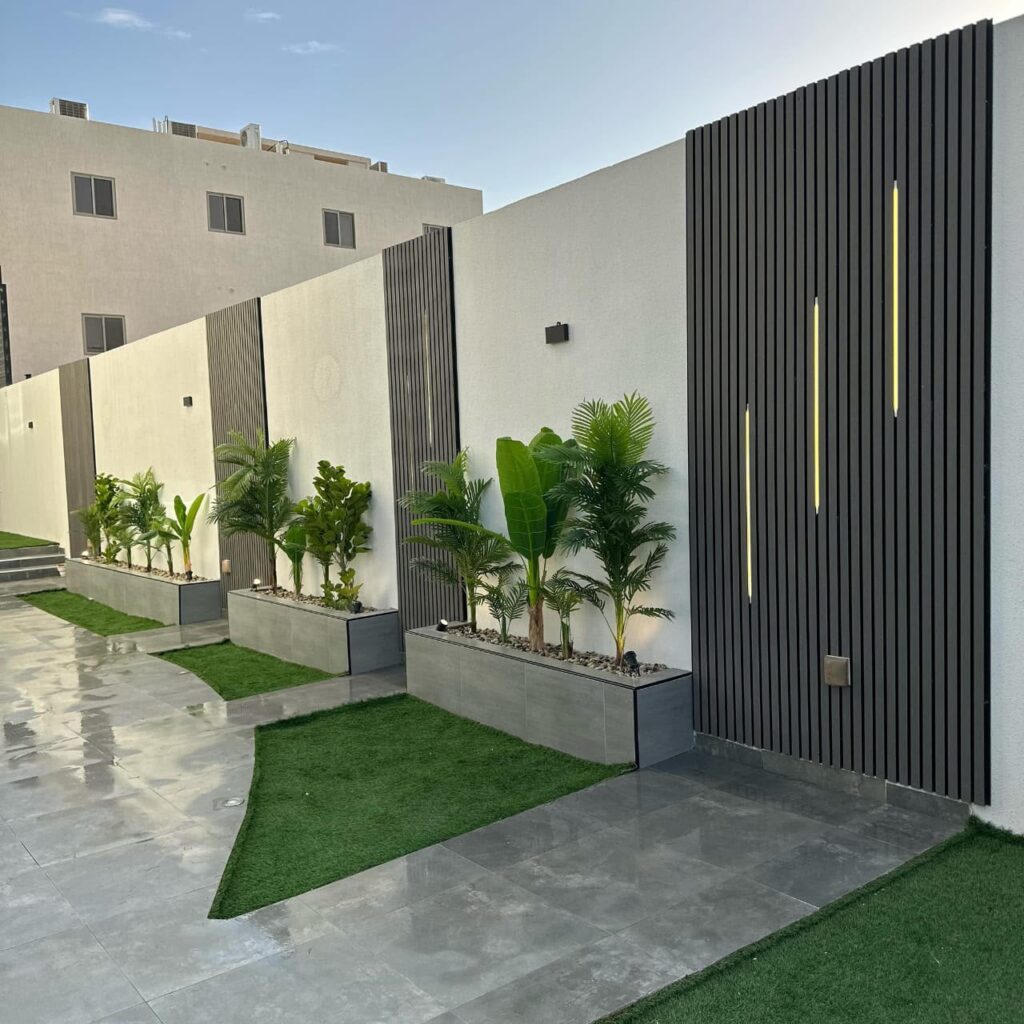 تكسيات جدارية سوداء مضاءة مع أحواض نباتات مودرن وعشب صناعي بالرياض تنفيذ مؤسسة رؤية